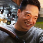 Mies katsoo hymyillen vaunukoppaan.